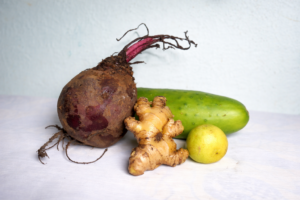 alt="Ingrédients frais pour cocktail détox : betterave crue, gingembre et concombre"