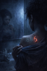 « Gros plan sur l'épaule de L'eyra révélant la marque rouge du chiffre 666 gravée sur sa peau, symbole de son combat entre l'ange et le démon. »