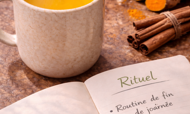 Recette lait d'or curcuma Tasse de lait d'or jaune vif saupoudrée de cannelle à côté d'un carnet de rituels