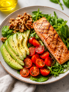 Une assiette colorée contenant un avocat coupé, des noix, des tomates cerises et du saumon grillé aliments bons pour le cœur